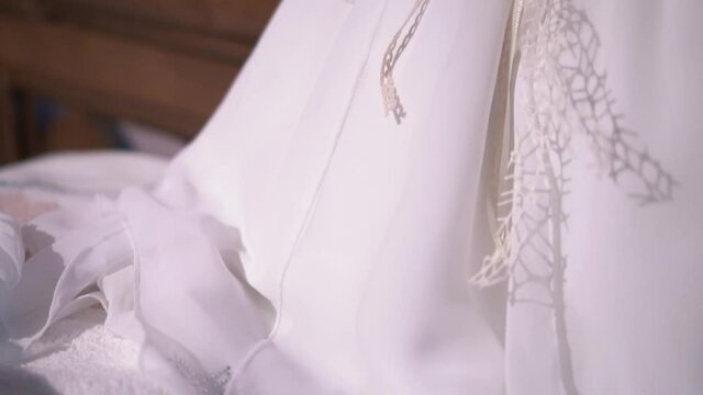 Beautiful traditional baptism dress for baby girl. Close up revealing shot