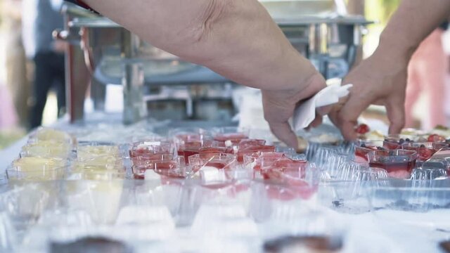 People taking sweets from the buffet served after baptism