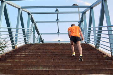 Sportsman jogging up the stairs in yellow running shoes.