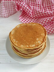 Pancakes with strawberries and mint on a white background