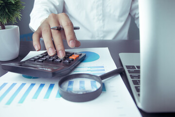 business people who use a calculator with financial concepts, spreadsheet data, business people use...