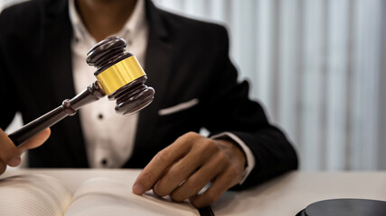 Fototapeta na wymiar Man judge hand holding gavel to bang on sounding block in the court room. Close up of lawyer holding gavel at desk. Man holding wooden gavel in the hand.