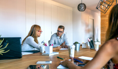 Young coworkers discussing a project in the office
