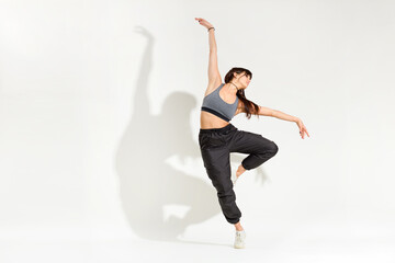 Fototapeta na wymiar Graceful young woman dancer performing a classic dance pose
