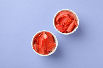 Bowls with pickled ginger on violet background