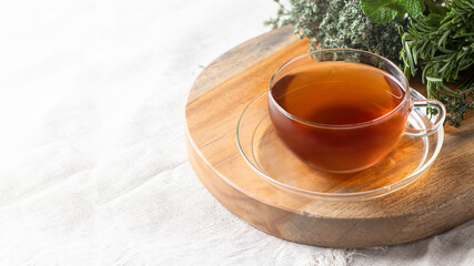 Herbal drink concept. Different aromatic plant rosemary, mint, thyme and glass of tea o linen table cloth.