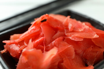 Black bowl with red pickled ginger, close up