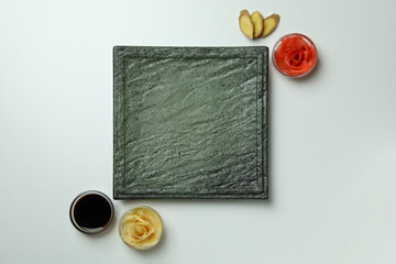 Empty plate, pickled ginger and soy sauce on white background, space for text