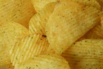 Tasty potato chips on whole background, close up