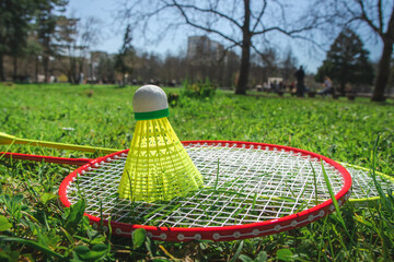 Bagminton rockets and ball in the green grass park in the spring