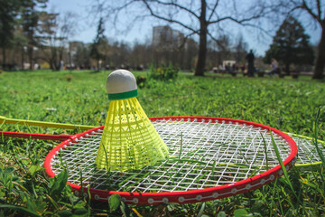 Bagminton rockets and ball in the green grass park in the spring