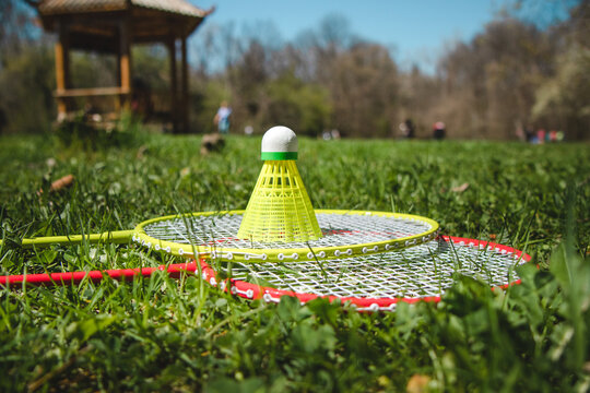 Bagminton rockets and ball in the green grass park in the spring