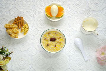 Red date rice porridge, eggs, oranges, shaqima and milk, healthy and nutritious breakfast, top view
