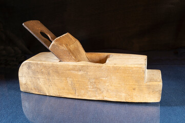Old wooden plane on the table with a reflection
