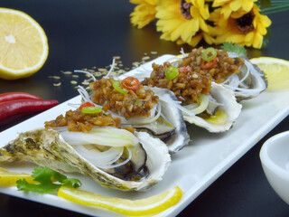 4 garlic vermicelli oysters in a white plate, delicious seafood