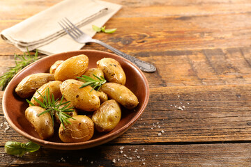 baked potato with rosemary on wood background