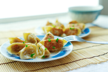 Close-up two plates of golden fried buns with fork in the plate, depth of field picture, traditional Chinese snack