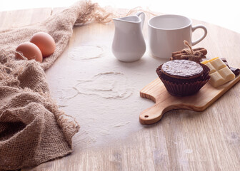 baking ingredients egg, flour, oil and muffin for baking on a wooden background