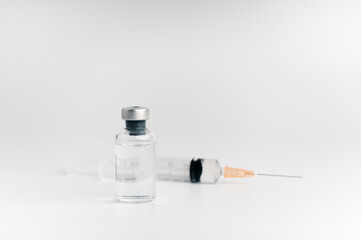 The vaccine vials, syringes and stethoscope are placed together on a white background. COVID-19 virus protection concept, vaccine invention and production concept.