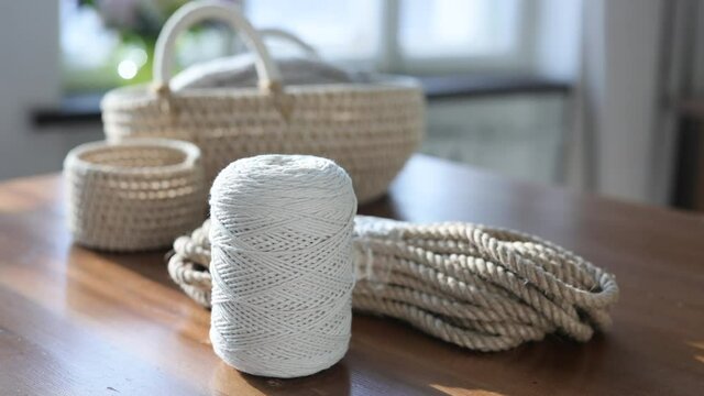 Handmade home decor made from organic jute fiber. Wicker jute baskets stand on a wooden table. jute rope and macrame rope. the concept of home decor and comfort in an eco-style.