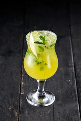 Glass of green apple mojito cocktail on the wooden background