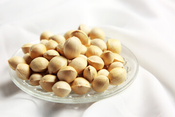 White background, pistachios in glass plate close-up, great in nutritional value