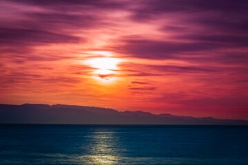 Fototapeta premium Abstract sunset over the sea. Colorful hazy sky