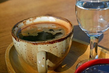 a cup of Turkish coffee with glass of water