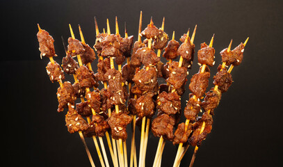 Grilled beef skewers on black background, traditional Chinese cuisine