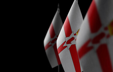 Small national flags of the Northern Ireland on a black background