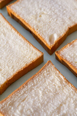 The slices of toast bread filling the picture are spread out on the table