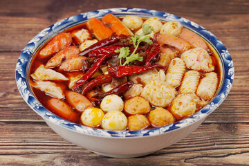 Hot pot on a wooden cutting board, ingredients: ham sausage, meatballs, crab sticks, pigeon eggs, shrimp dumplings, etc.