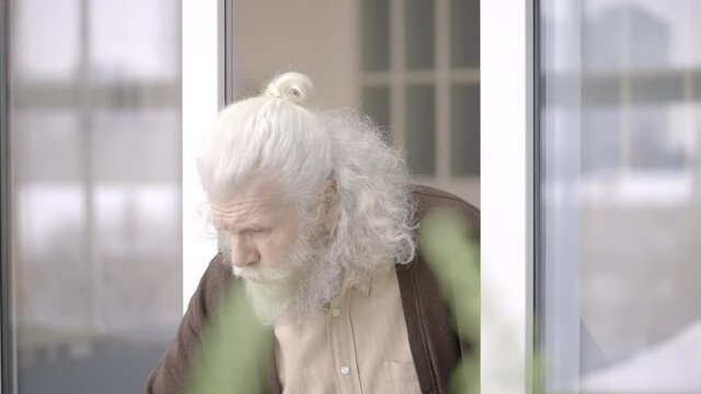 Cranky old man shouting at noisy children outdoors, impatient grandfather