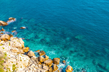 Top view of turquoise water by the rocks. Crystal clear water, background, copy space 