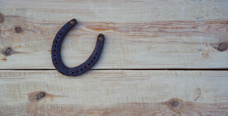 Old rusty horseshoe on a pine board. Natural wood background. Wood texture. Place for text.