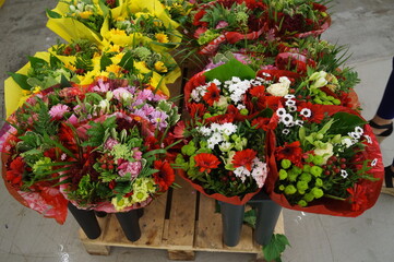 gift-wrapped bouquets of red white yellow green flowers