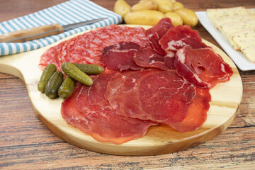 fromage à raclette et charcuterie sur une planche à découper