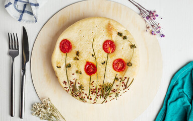 cake with a picture of flowers from tomatoes on a wooden base on a light background top view