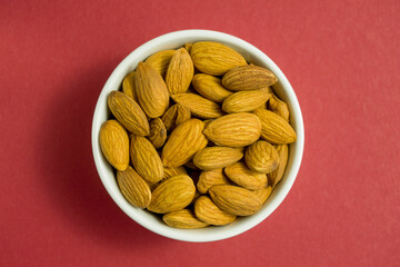 almonds in a white dish on a red background