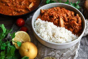 Traditional curry and ingredients. Tikka Masala chicken and rice. Indian food. Close up. Copy space. Wooden background.