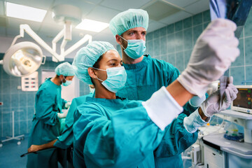 Fototapeta na wymiar Team of surgeons in the operating room preparing for surgery