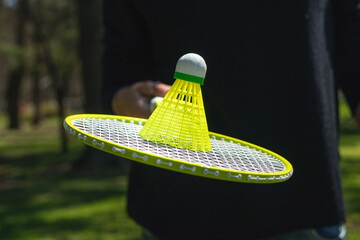 A woman with a racket plays badminton. Blurred woman in the background holding a badminton racket and a ball, a relaxing weekend with play and sports