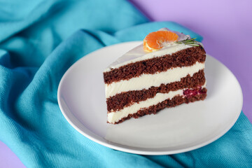 A piece of chocolate cake with vanilla cream. Berries inside and a piece of tangerine on top.
