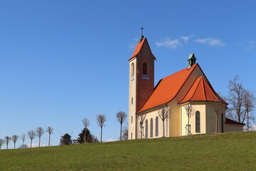 Church in the village of Nova Ves. Church with a red roof with a blue sky