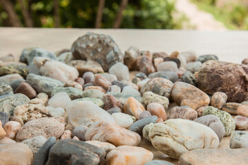 multicolored river pebbles stones randomly lie on the sand next to the sea. Macro photography. Close-up background concept, copy space