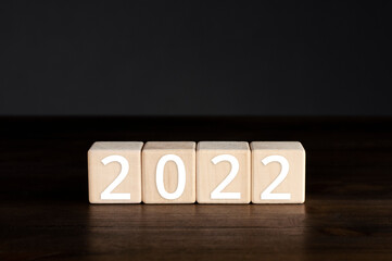 Wooden cubes on the table. New year 2022. Figures.