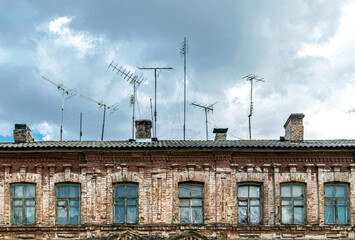 Fototapeta premium Obsolete rusty television antennas on the roof of an old house. Analog technology
