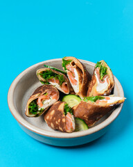 Stack of pancakes with salted salmon and cream cheese Philadelphia in a bowl. Over bright blue background.