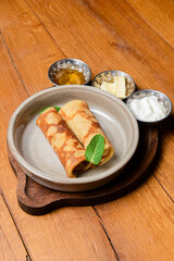 Stack of pancakes with salted salmon and cream cheese Philadelphia in a bowl. Over rustic wooden background.