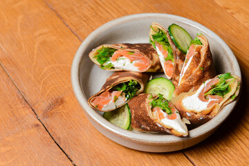 Stack of pancakes with salted salmon and cream cheese Philadelphia in a bowl. Over rustic wooden background.